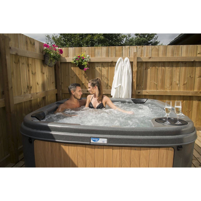 RotoSpa DuraSpa S160 Granite grey and teak lifestyle outdoor arrangement with couple in tub
