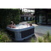 RotoSpa DuraSpa S160 Light grey and grey lifestyle outdoor arrangement with 2 people drinking in tub