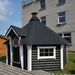 Viking Industrier Sauna Cabin 16.5m² black roof and white pillars beside building