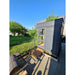 Viking Industrier Sauna Cube 2 x 2m outdoor lifestyle black painted on wooden platform under the sun